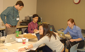 Cassie sits at a long table alongside several peers at the RotaCare clinic.